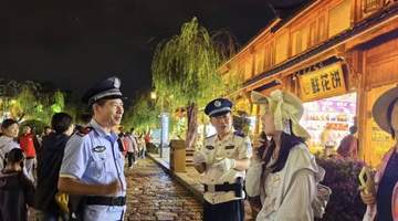 丽江古城暑期游客遇惊喜 白衬衣警官夜间巡逻成安心“路标”