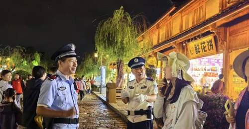 丽江古城暑期游客遇惊喜 白衬衣警官夜间巡逻成安心“路标”