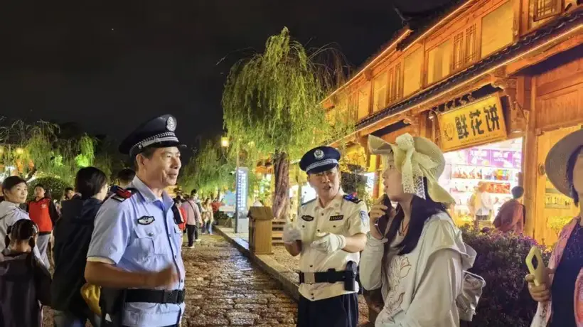丽江古城暑期游客遇惊喜 白衬衣警官夜间巡逻成安心“路标”