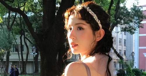 林间柔光里抱花氛围感拉满 哈妮克孜淡紫纱裙卷发解锁夏日写真童话体验