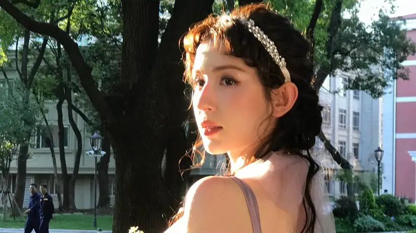 林间柔光里抱花氛围感拉满 哈妮克孜淡紫纱裙卷发解锁夏日写真童话体验